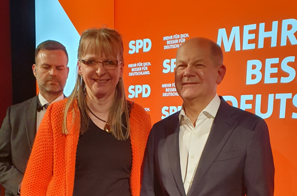 Foto einer Frau und eines Mannes, die in die Kamera lächeln. Sie stehen vor einer roten Fotowand der SPD.