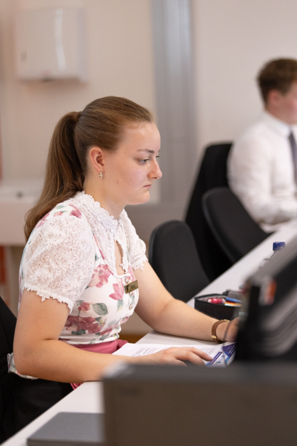 Eine junge Frau blickt konzentriert auf einen Computerbildschirm