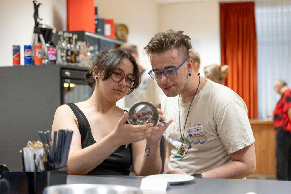 Zwei junge Menschen begutachten ein Utensil aus der Küche