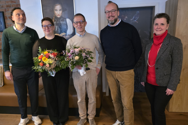 Fünf Menschen posieren für ein Gruppenfoto.
