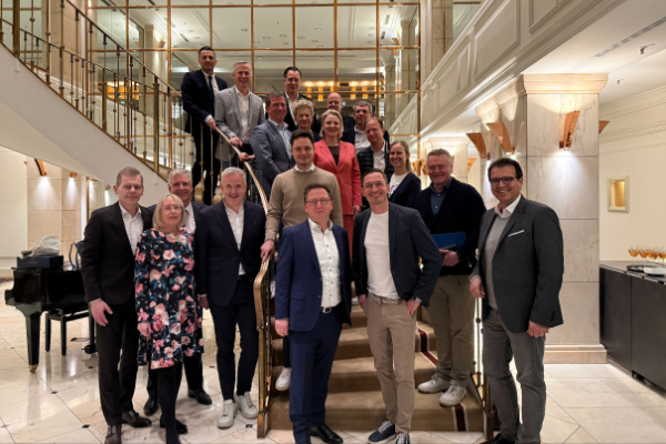 Ein Gruppenfoto mit vielen Menschen auf bzw. vor einer Treppe.
